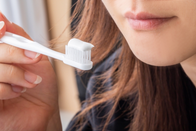 歯ブラシに歯磨き粉をつける女性