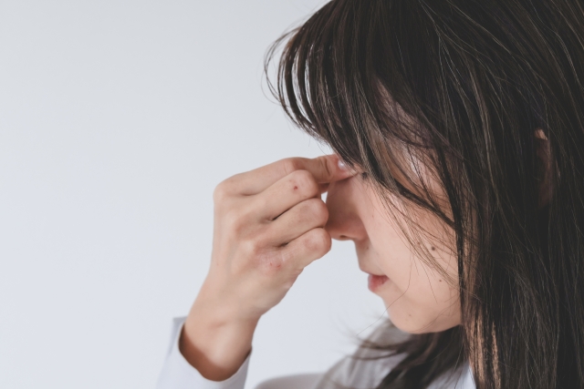 目頭をおさえる女性