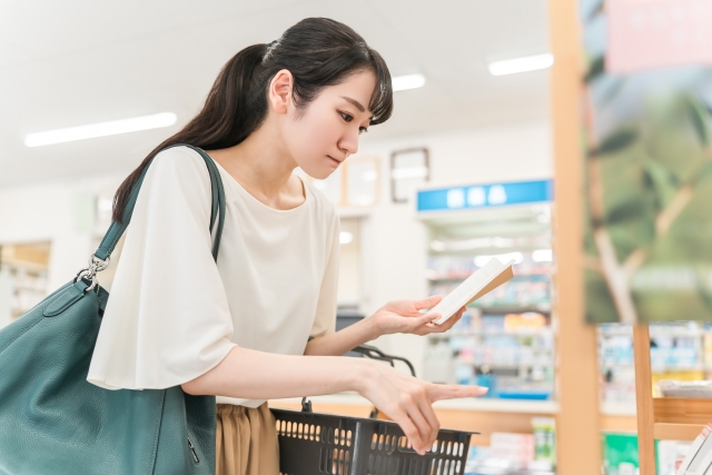 ドラッグストアで薬を買う女性